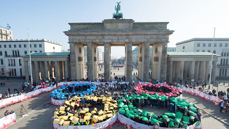 Begeisterung in Berlin? Schüler bilden am 19 Februar vor dem Brandenburger Tor die Olympischen Ringe nach. 