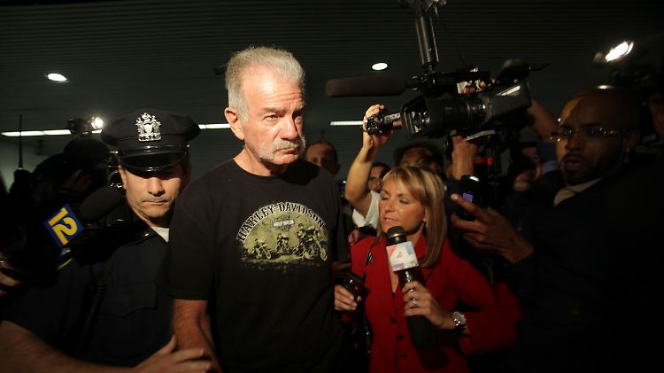Jones in New York am Flughafen. Auf seinem T-Shirt steht "Harley Davidson".