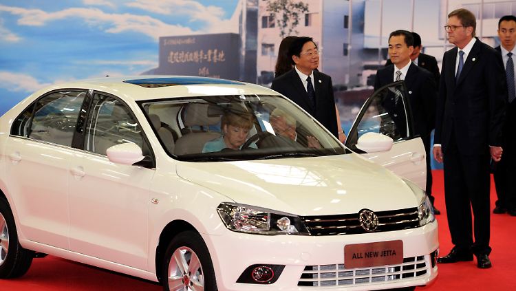 FAW-Chef  Xu Jianyi (Mitte) im vergangenen Sommer mit Kanzlerin Angela Merkel (im VW-Jetta sitzend) und VW-Chef Martin Winterkorn (zwischen beiden).
