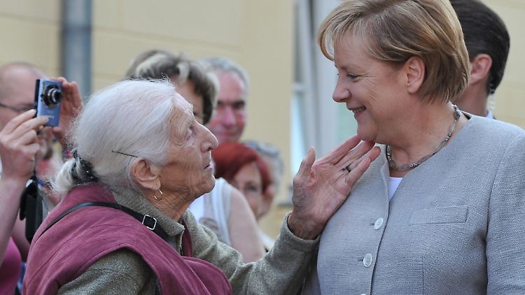 Auf dem richtigen Weg? Merkel wird von einer Bewohnerin in Diedersdorf begrüßt.