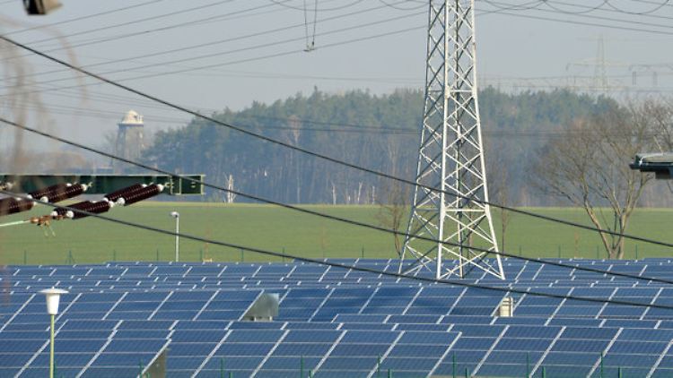 Ein Strommast des 50 Hertz Transmission Control Center in Neuenhagen (Brandenburg) zwischen Solaranlagen. Der Übertragungsnetzbetreiber musste die zu erwartenden Spannungsverluste durch die Sonnenfinsternis ausgleichen.