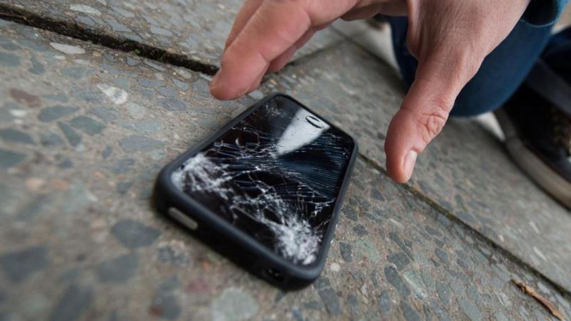 Ein Sturz auf den Asphalt - schon ist das Display kaputt. Wer ein Smartphone zur Reparatur bringt, muss oft lange warten und viel bezahlen. Zu dem Ergebnis kommt Stiftung Warentest. Foto: Franziska Gabbert