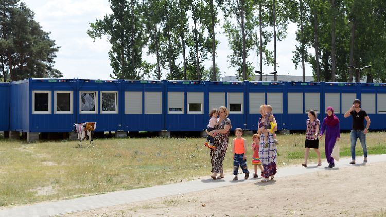 Asylbewerber aus der russischen Föderation in Eisenhüttenstadt in der Erstaufnahmeeinrichtung für Flüchtlinge vor Unterbringungscontainern. 