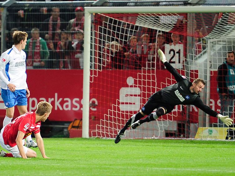 Der Cottbuser Nils Petersen (m) überwindet den Karlsruher Torwart Kristian Nicht zum 1:0 - nach 19 Sekunden.