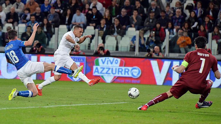 Der Brite Kieran Gibbs (M.) versucht, den Ball an Italiens Torhüter Gianluigi Buffon vorbeizuspielen. Daraus wird aber nichts. 