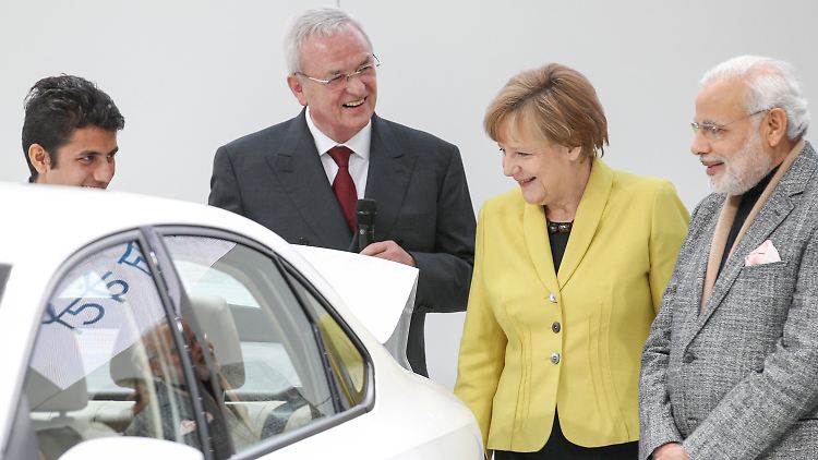 Martin Winterkorn zeigt Angela Merkel und Narendra Modi ein Auto.