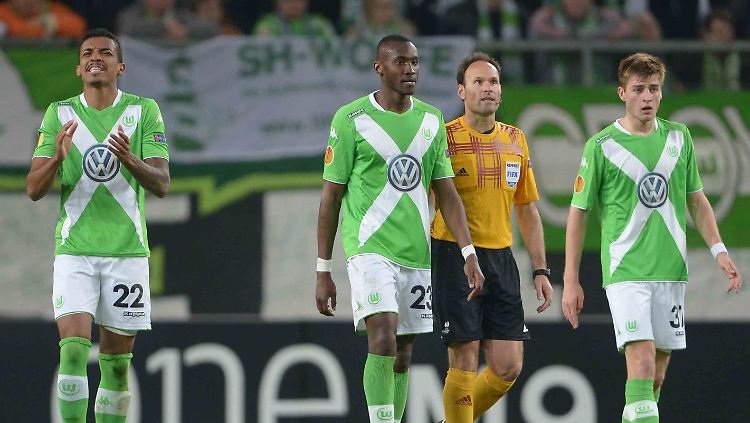 Die Wolfsburger Luiz Gustavo (l.), Josuha Guilavogui, Robin Knoche gehen neben Schiedsrichter Antonio Mateu Lahoz (gelbes Trickot) aus Spanien über den Platz.