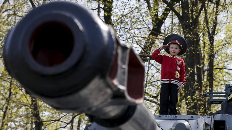 Frühling in der Ukraine: Mit der Militärmütze seines Vaters auf dem Kopf posiert ein Junge in Kiew auf einem Artilleriepanzer.