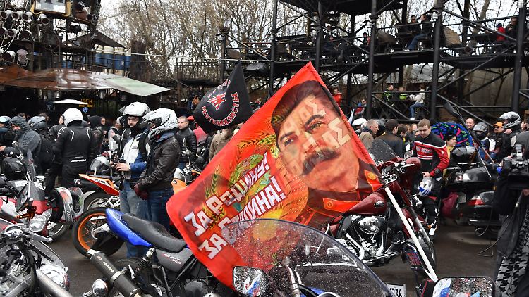 Eine Fahne mit dem Gesicht Josef Stalins an einem "Nachtwölfe"-Motorrad.
