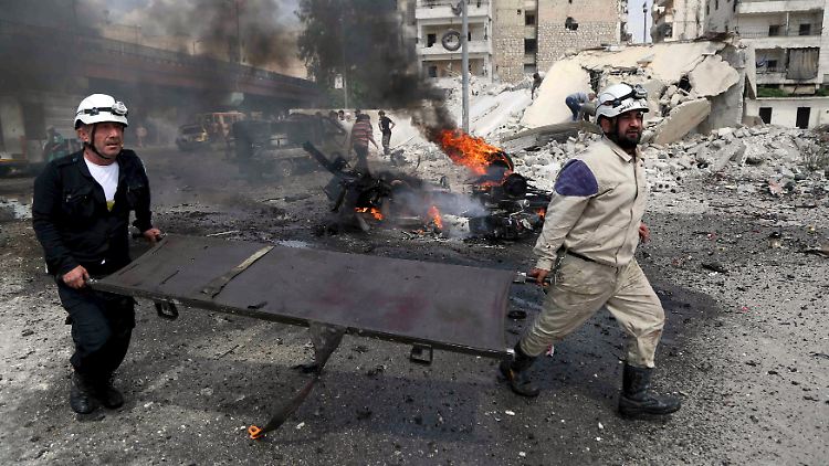 Rettungskräfte eilen zu der Bushaltestelle in Aleppo, die von der Fassbombe getroffen wird.