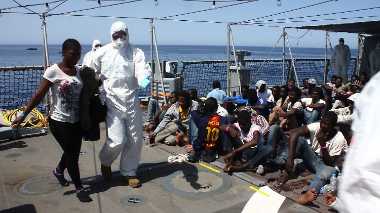 Ankunft in Europa: Aus Furcht vor ansteckenden Krankheiten tragen die Marinesoldaten Schutzanzüge wie im Operationssaal.