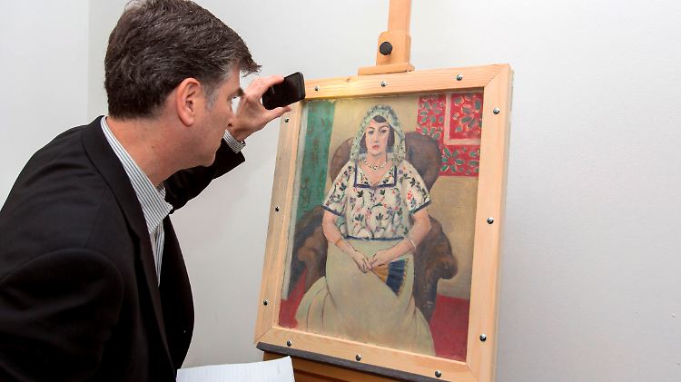 Der Vertreter der Familie Rosenberg, Christopher Marinello inspiziert das Bild nach der Rückgabe.
