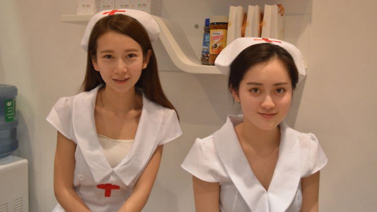 Zwei als Krankenschwestern kostümierte Hostessen in Peking. 