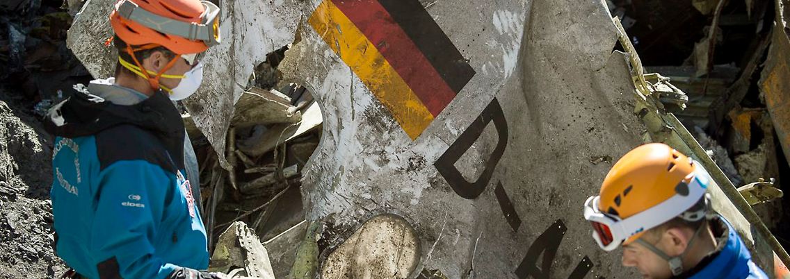 Bergungskräfte mit einem Trümmerteil des Flugzeugs.