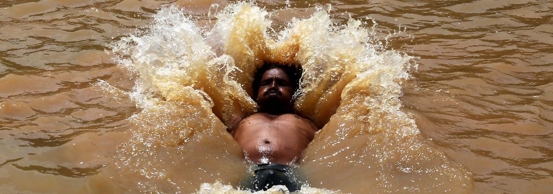 Ein Inder sucht Abkühlung im Wasser.