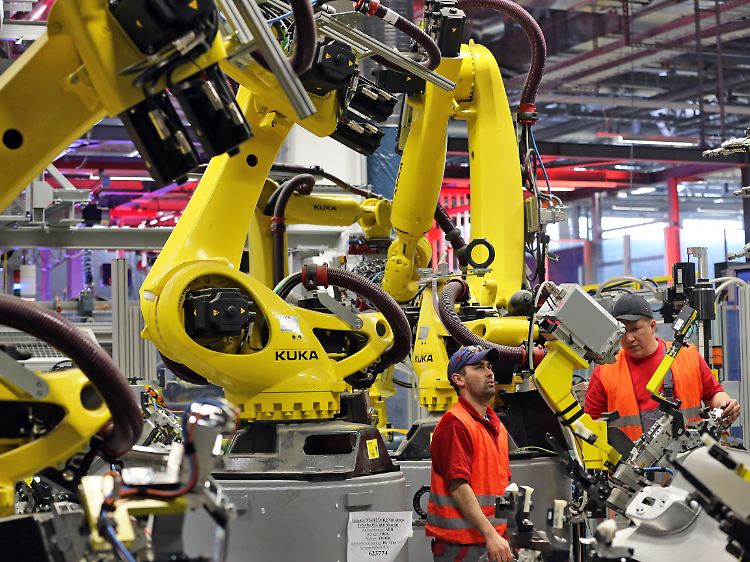 Mechatroniker installieren in Leipzig einen Roboter in der neuen Karosseriefertigung des Sportwagenbauers Porsche.