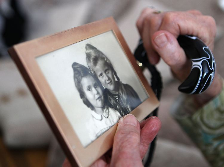 Eine Frau betrachtet ein Bild aus ihrer Jugendzeit. Erinnerungen werden bei Alzheimer-Patienten ausgelöscht.