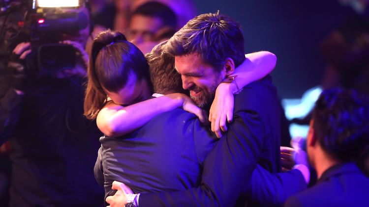 Die Schauspieler Frederick Lau (M) und Laia Costa umarmen den Filmemacher Sebastian Schipper.