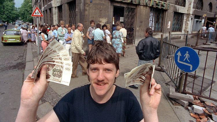 Nach langem Schlangestehen vor einer Leipziger Bank freut sich dieser junge Mann über seine ersten D-Mark-Banknoten.