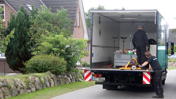 Polizeibeamte und Spezialisten des Kampfmittelräumdienstes transportieren unter größter Vorsicht die Waffen aus dem Haus in Winnert.