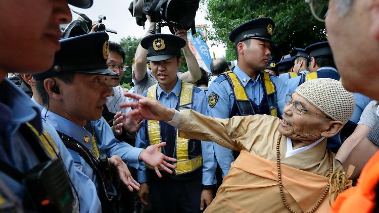 Ein buddhistischer Mönch protestiert gegen die Abkehr vom japanischen Pazifismus. Viele Menschen sind gegen die neue Militärdoktrin.