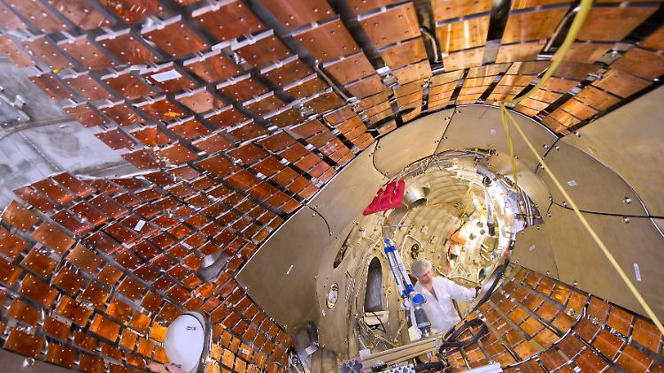 Ein Monteur arbeitet im ringförmigen Plasmagefäß des Forschungsreaktors.