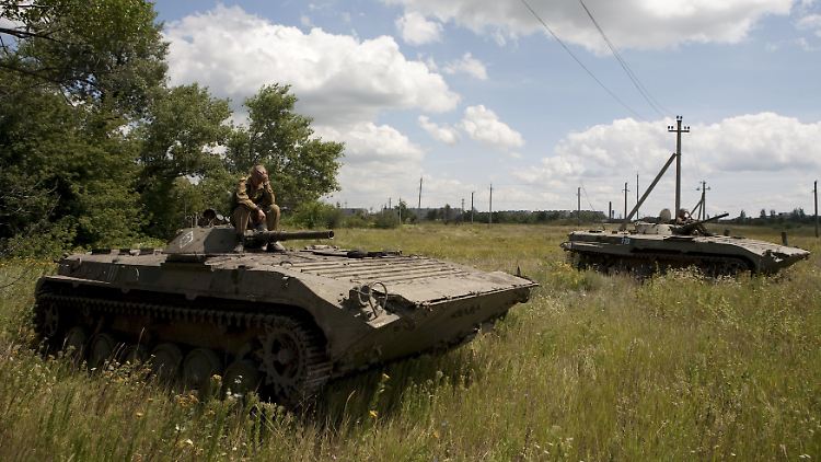 Separatisten machen Pause auf ihren Panzern in der Nähe von Donezk. Die Kämpfe in der Ostukraine sind trotz des verabredeten Waffenabzugs erst einmal weitergegangen.