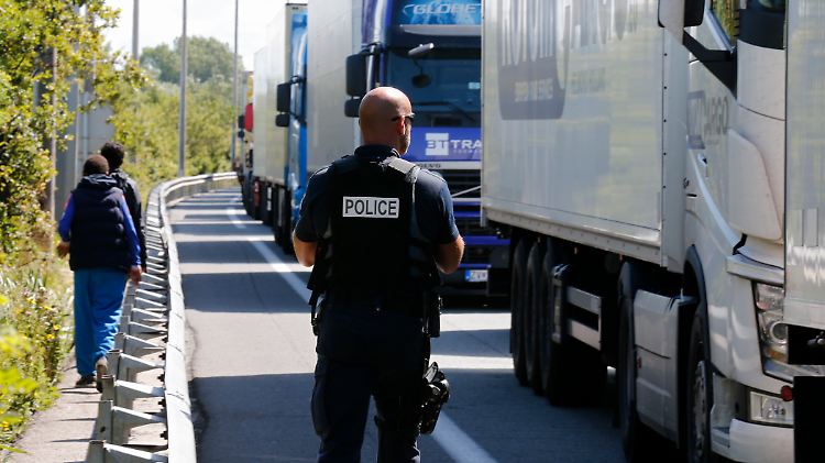 Ein französischer Polizist passt auf die Lastwagen-Schlange bei Calais auf.