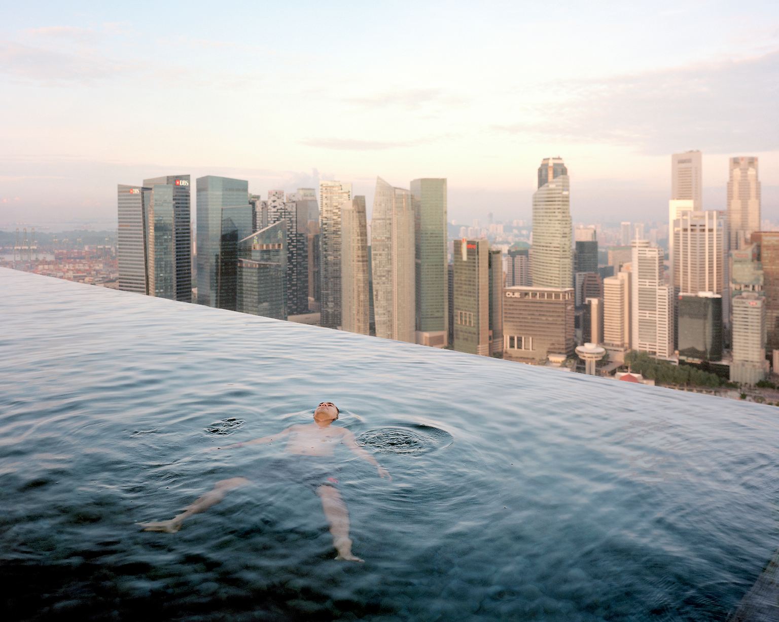 In einer Fotoausstellung begegnen sich zwei Welten: Reich trifft Arm. Hier schwimmt ein Mann im Pool eines Hotels in Singapur.