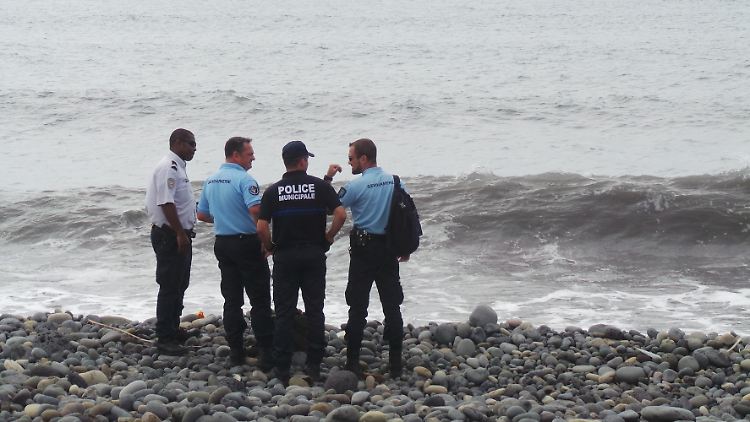 Polizisten suchen nach weiteren Wrackteilen auf der französischen Insel La Réunion.