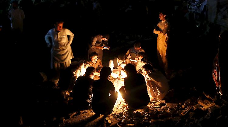 In Kabul zünden Menschen Kerzen an, nachdem dort eine Lastwagenbombe explodiert war.
