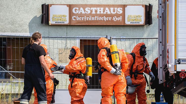 Großeinsatz bei Engelmannsreuth: Einsatzkräfte der Feuerwehr ziehen sich unweit der Unfallstelle Ganzkörper-Schutzanzüge an.