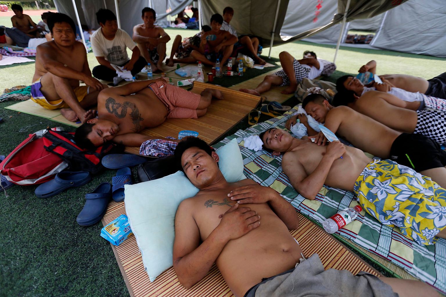 Der Morgen danach: Obdachlos gewordene Bewohner von Tianjin liegen auf Matten im Freien.