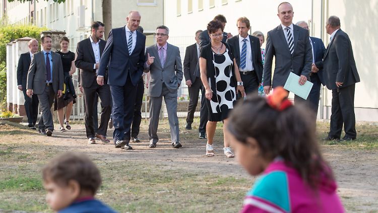 Brandenburgs Ministerpräsident Dietmar Woidke (5. v. li.) und Bundesinnenminister Thomas de Maizière (re. daneben) besuchen zusammen mit anderen Personen die Erstaufnahmestelle für Asylbewerber Eisenhüttenstadt. In der Einrichtung samt Außenstellen leben rund 2100 Menschen, davon knapp 400 in Zelten.