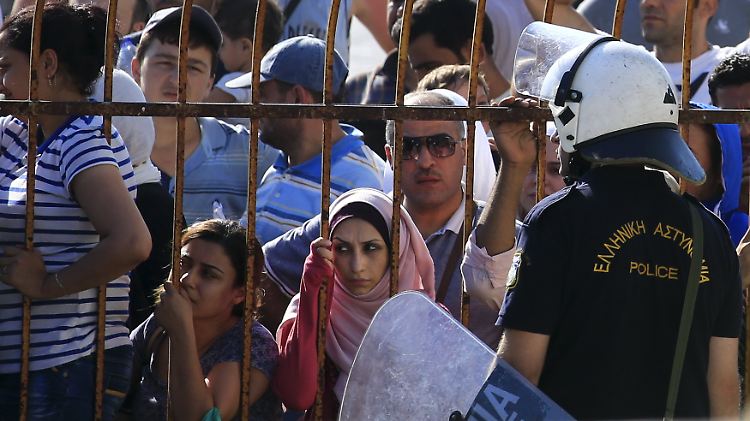 Flüchtlinge sind bei gleißender Hitze in einem Stadion eingepfercht.