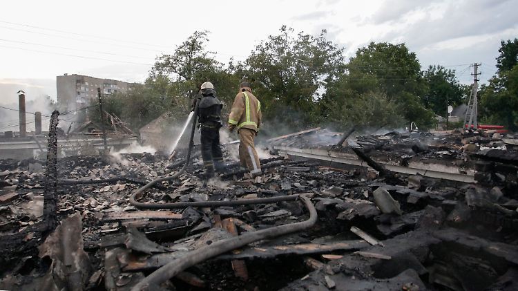 Feuerwehrmänner im Einsatz: Bei den Gefechten soll es auch zivile Opfer gegeben haben. Dieses Haus ist vollständig zerstört worden.