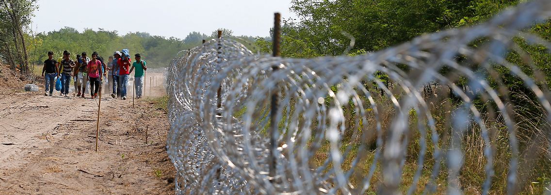 Flüchtlinge am Grenzzaun an der serbisch-ungarischen Grenze.