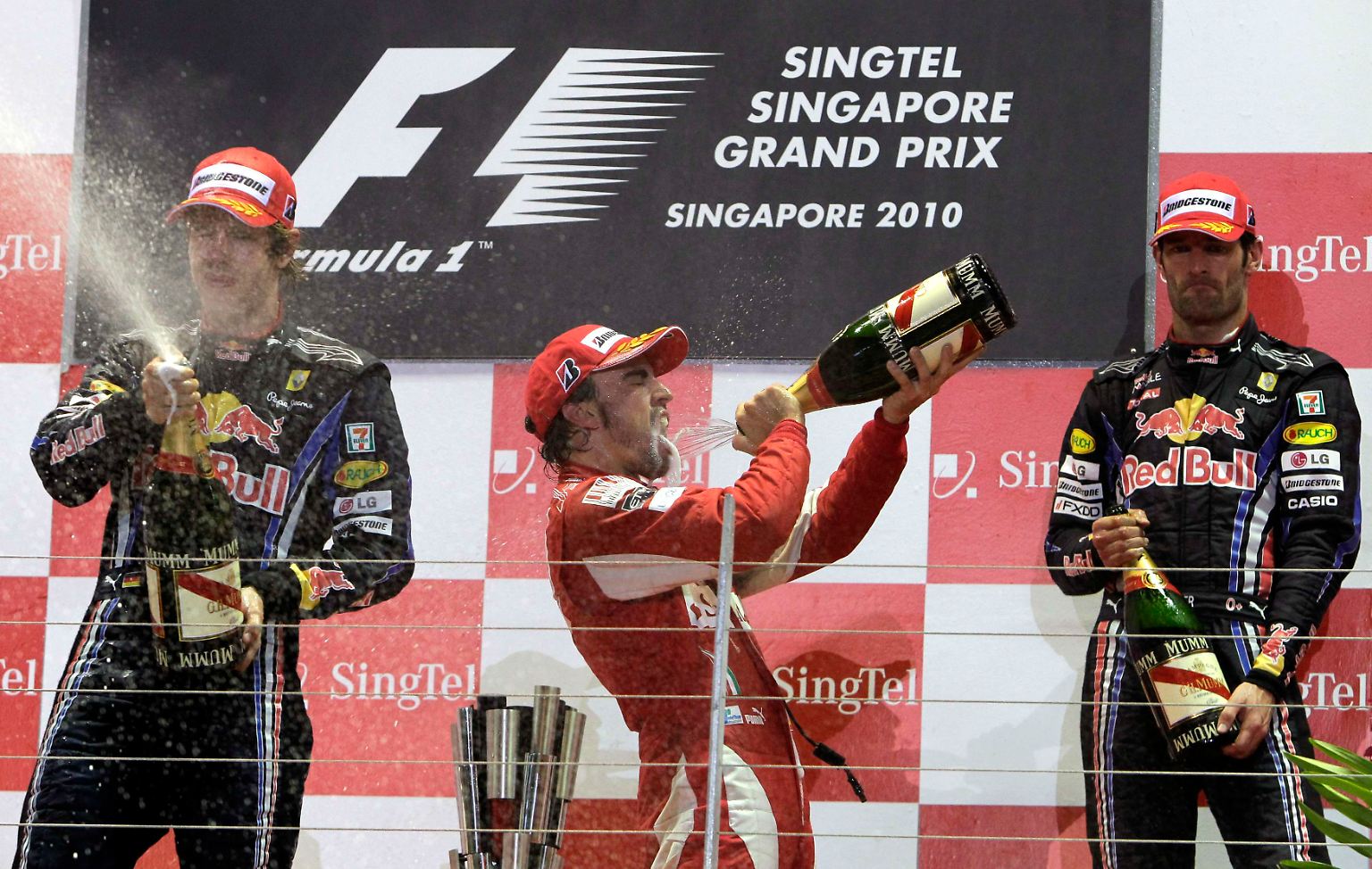 Bei der Siegerehrung des Großen Preises von Singapur spritzte Sebastian Vettel, links, zwar mit Champagner um sich. Aber einen zünftigen Schluck auf den Sieg nehmen konnte nur sein Nachbar auf dem Treppchen, Fernando Alonso.