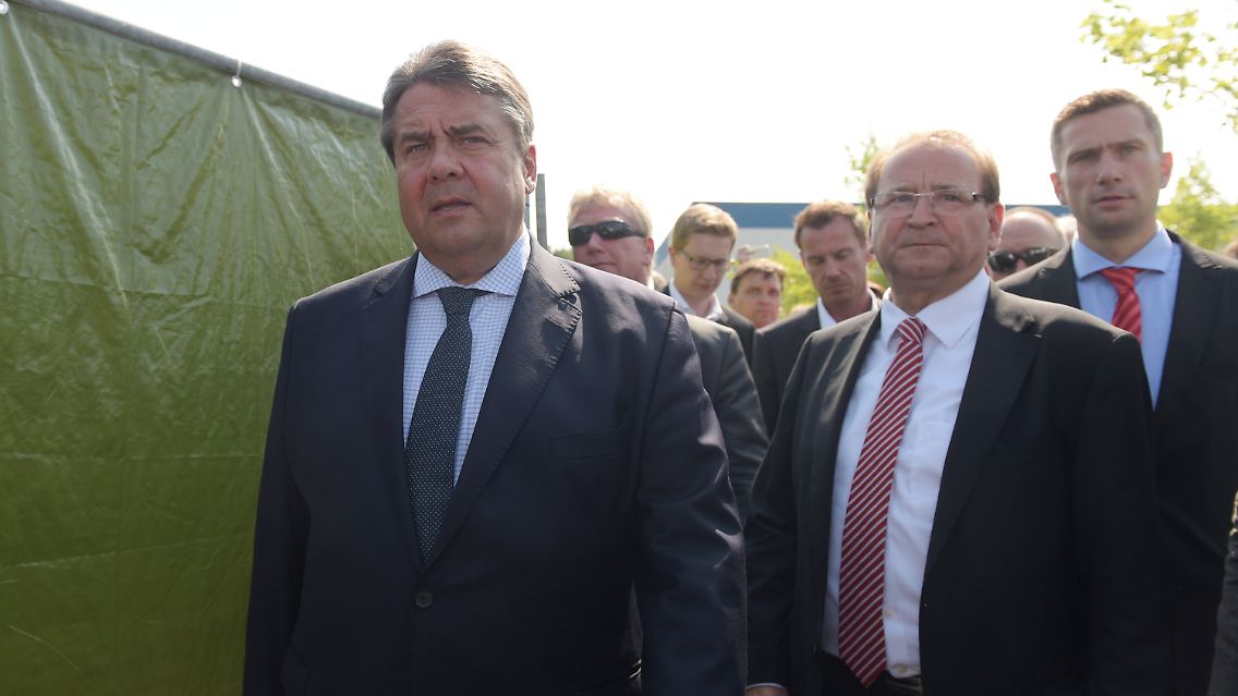 Heidenaus Bürgermeister Jürgen Opitz (Mitte, CDU), Sachsens Wirtschaftsminister Martin Dulig (rechts, SPD) und Bundeswirtschaftsminister Sigmar Gabriel (SPD) verlassen die Notunterkunft für Flüchtlinge in Heidenau.