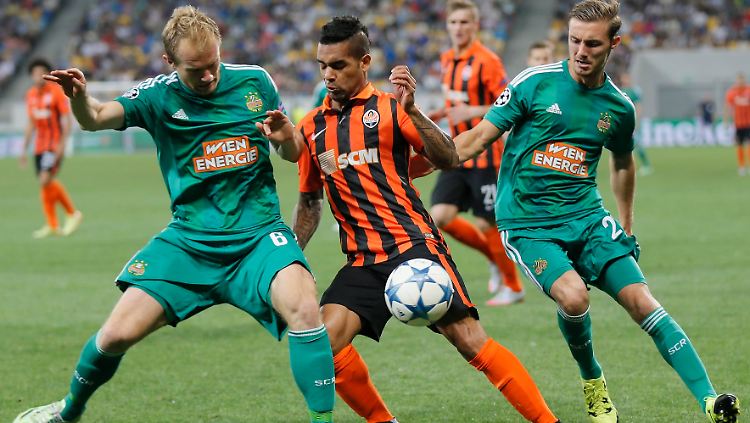 Schachtjors Alex Teixeira (m.) behauptet den Ball gegen Rapid Wiens Mario Sonnleitner (li.). 