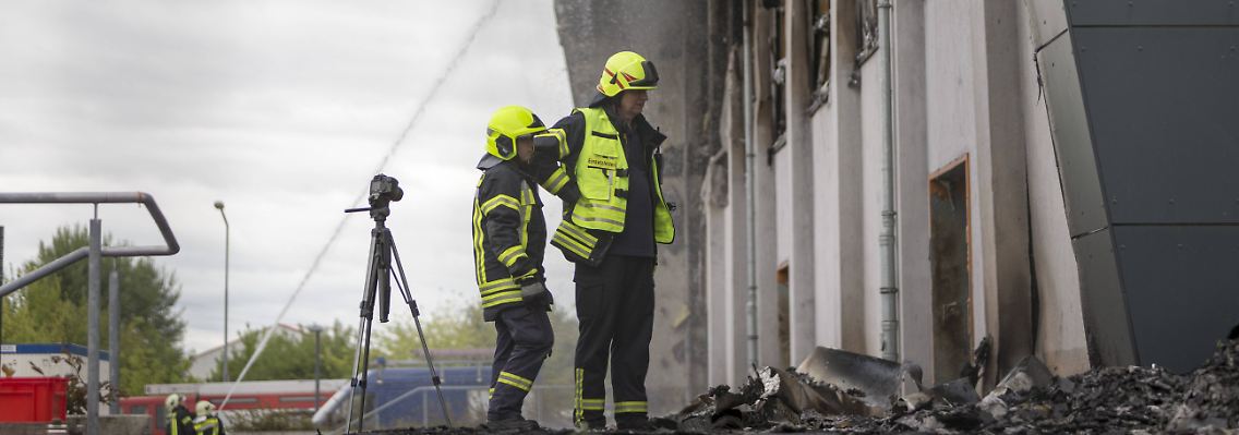 Feuerwehrleute an der abgebrannten Halle in Nauen.