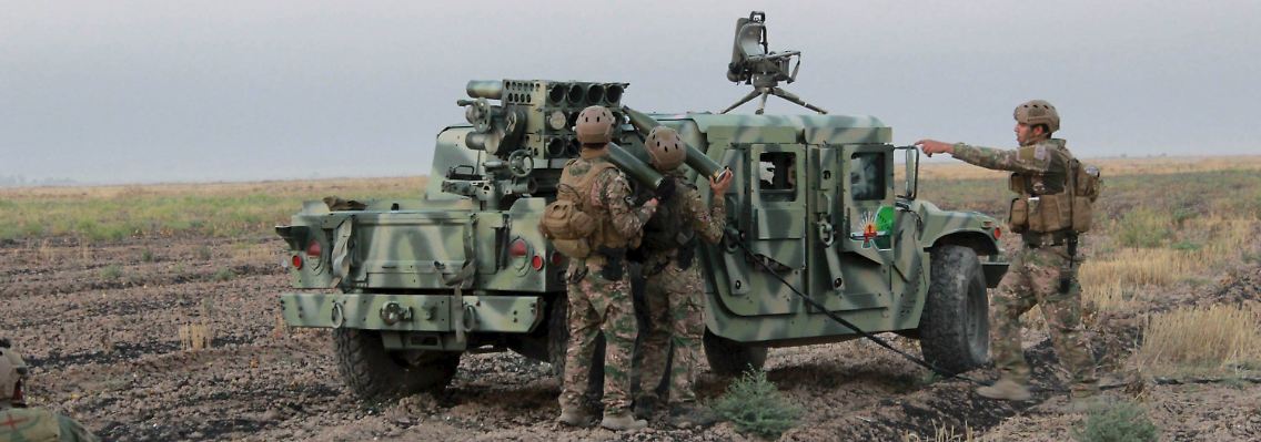 Kurdische Peshmerga laden einen Raketenwerfer an der irakischen Front.