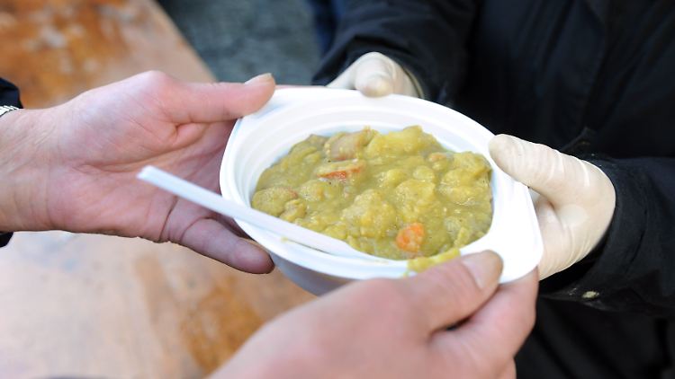 Ein mittelloser Mann erhält von einer Mitarbeiterin des Vereins "Die Bremer Suppenengel" eine Mahlzeit.