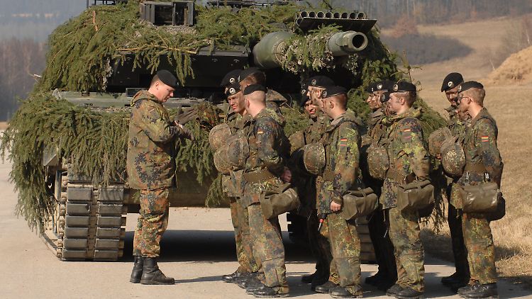 Mitglieder des Panzerbataillons 104 vor einem Leopard II A6 Panzer in der Oberpfalzkaserne in Pfreimd.