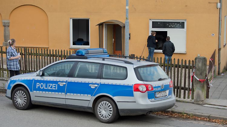 Ermittler vor dem eingeworfenen Fenster der Asyl-Unterkunft in Salzhemmendorf. 