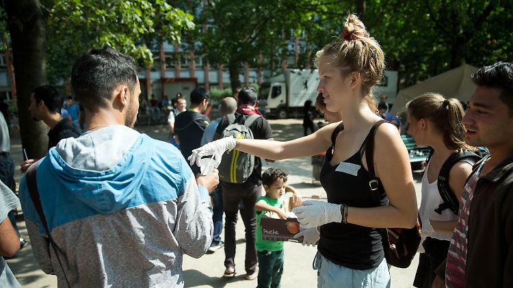 Eine ehrenamtliche Helferin versorgt Flüchtlinge in Berlin mit Essen.
