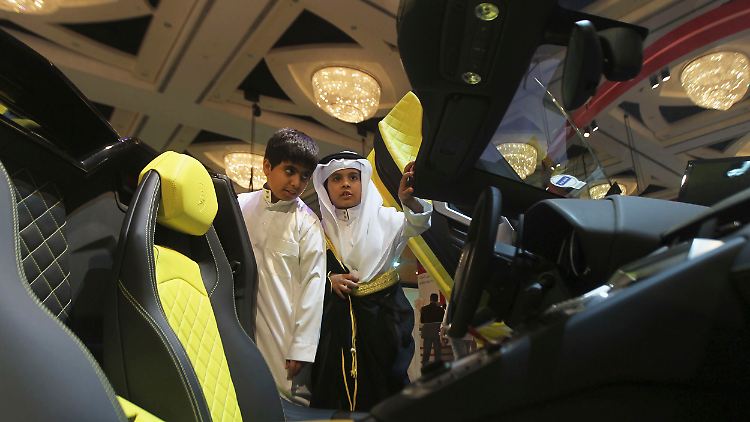 Kinder bestaunen einen Lamborghini in einem Autosalon in Riad.