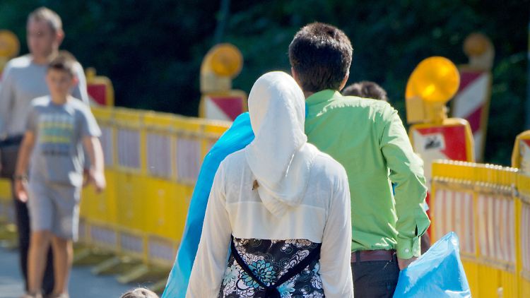 Flüchtlinge gehen mit ihrem Hab und Gut in Gießen zur Zentralen Erstaufnahmeeinrichtung des Landes.