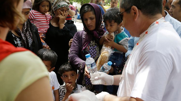 Auf dem Victoria-Platz in Athen: Helfer vom griechischen Roten Kreuz verteilen Wasser und Lebensmittel an die Flüchtlinge.