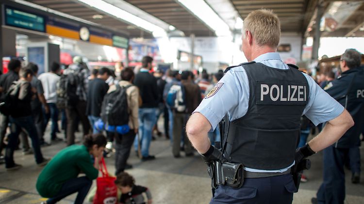 Polizisten begleiten Flüchtlinge, die kurz zuvor mit einem Zug aus Budapest angekommen sind, im Münchner Hauptbahnhof zu einem Sonderzug begleitet, der sie nach Dortmund fahren soll.